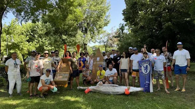 The team with the cardboard boats they built at a team-building event